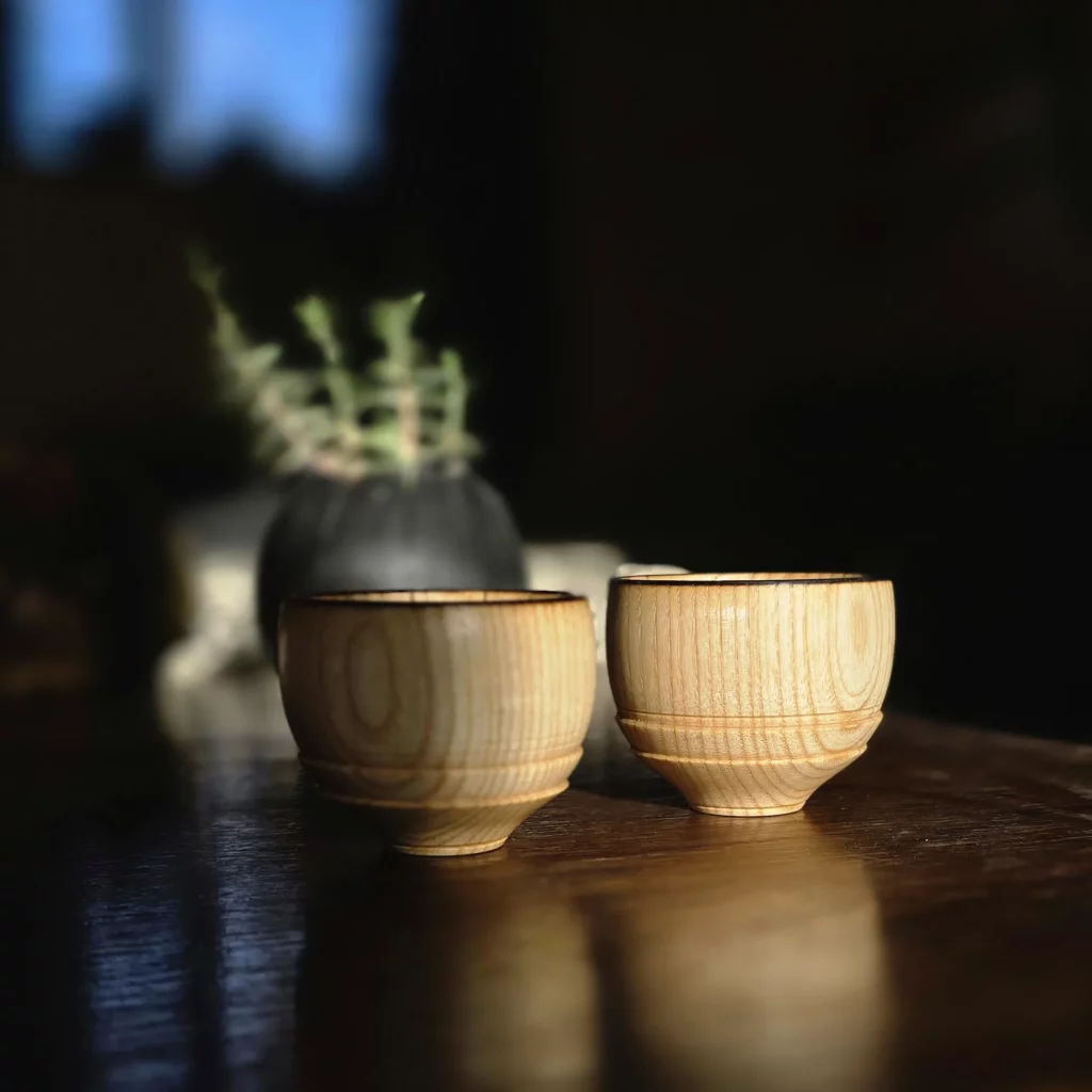 Petits pots en bois posé sur une table, entre ombres et lumières